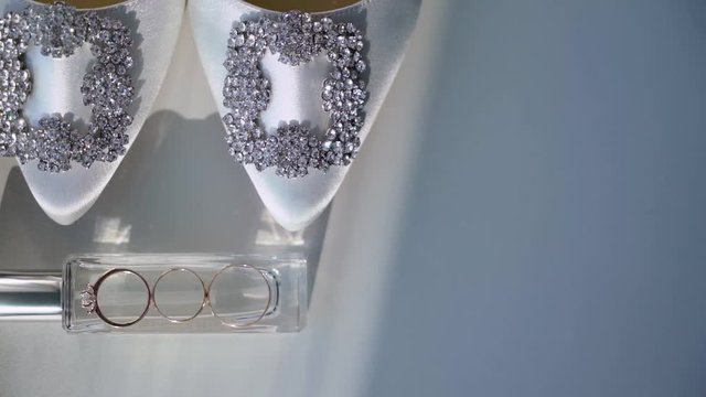 Wedding rings and bridal shoes. Pair of marriage symbols. Love of bride and groom becoming wife and husband. Matrimony symbol