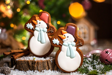 Holiday traditional food bakery. Two gingerbread happy snowman in hat and scarf in cozy decoration...