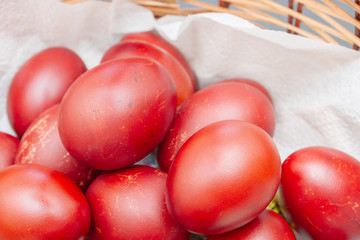 Painted eggs in onion peel lay in the wicker basket
