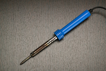 The soldering iron lies on a table, close up