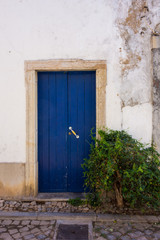 Alte blau lackierte Tür mit modernem Türgriff in altem Gemäuer