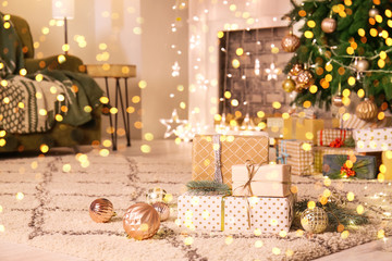 Many gift boxes under Christmas tree in room