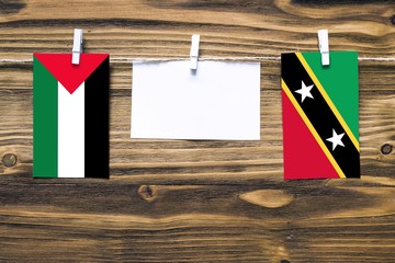 Hanging flags of Palestine and Saint Kitts And Nevis attached to rope with clothes pins with copy...