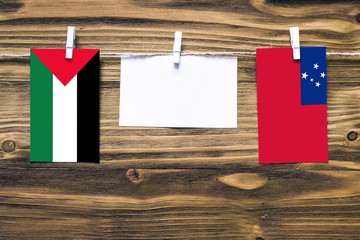 Hanging flags of Palestine and Samoa attached to rope with clothes pins with copy space on white...