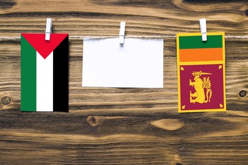 Hanging flags of Palestine and Sri Lanka attached to rope with clothes pins with copy space on...