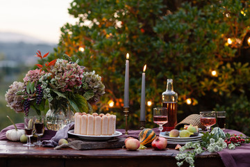 Beautiful and elegant table setting for a romantic date for a couple. Private terrace outside the restaurant. Lights on background