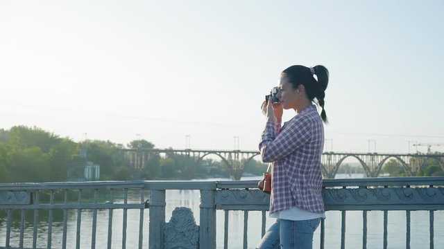 Slow Motion Beautiful Woman Taking Pictures on Retro Camera Standing on Bridge Morning