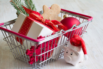 Abstract Christmas shopping in basket and piggy bank with Santa Claus hat