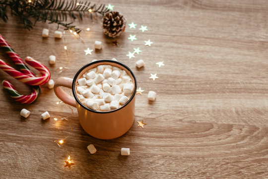 Christmas moody picture with pink cup of coffee with marshmallows and confetti