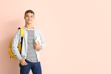 Portrait of teenage schoolboy on color background