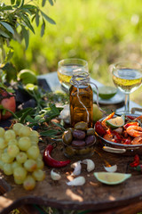 Romantic italian lunch outside of a couple: copper pan with delicious and spicy fried shrimps with herbs and garlic, wine, olives. Luxury lifestyle, gourmet food
