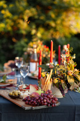 Dinner party outside to celebrate special occasion. Light snacks, fruit, cheese. Red candles as...
