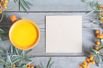Sea buckthorn berry tea and wood table background empty paper mock up empty space for text