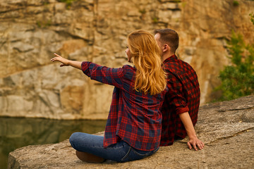 Couple of tourists exploring a new places. Handsome couple on nature near the lake at forest background.