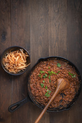 Vegan refried beans cooked in cast iron pan, pickled onion slices. Copy space.