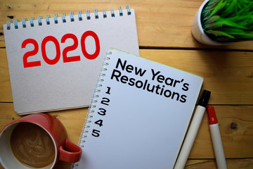 2020 New Year's Resolutions write on the book with wooden table background