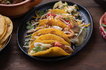 Mini street vegetarian corn tacos and side filling: tomatoes, queso, avocado, refried beans