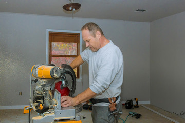 Man cut the wooden molding with circular saw