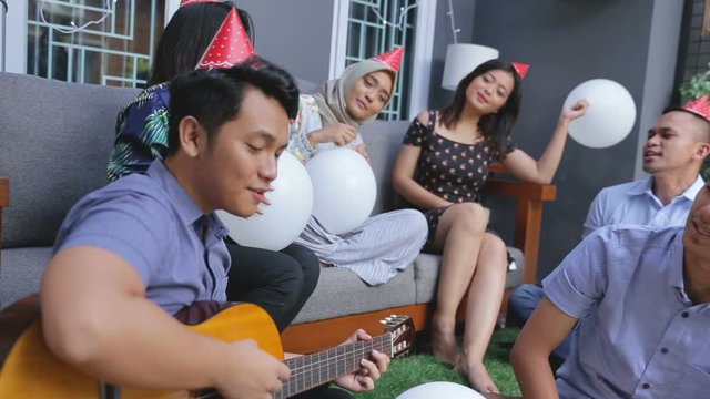 Group of friends enjoying brithday party and singing together