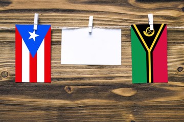 Hanging flags of Puerto Rico and Vanuatu attached to rope with clothes pins with copy space on...