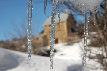 ice stalactites and behind an old barn