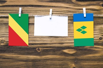 Hanging flags of Republic Of The Congo and Saint Vincent attached to rope with clothes pins with...