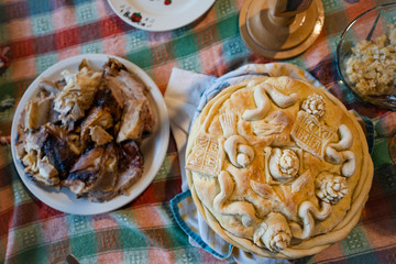 High angle view on traditional orthodox slava bread in Serbia for the saint day religion with meat on the table at family home