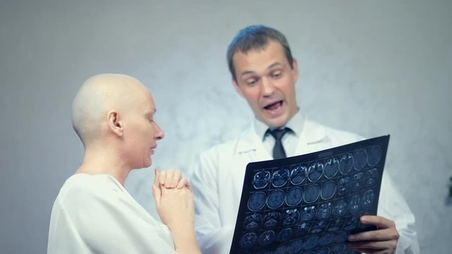 young bald woman at the doctor’s office, consultations on the results of tomography, good news.