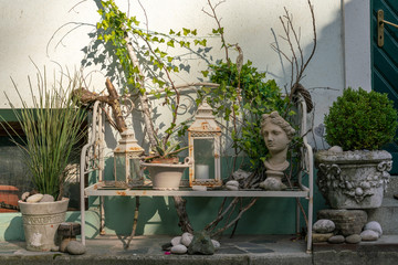 Various decorative objects with vintage aesthetics on a bench located on a sidewalk