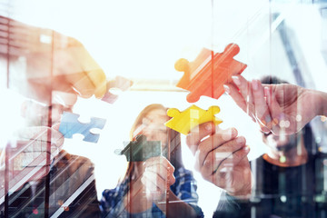 Business people join puzzle pieces in office. Concept of teamwork and partnership. double exposure with light effects - obrazy, fototapety, plakaty