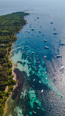 aerial drone shot view of coast line of Ile Sainte Marguerite and yachts in mediterranean sea, south France
