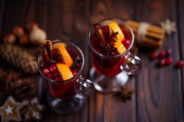 Christmas holidays atmosphere, cold winter day. Warming mood. Mulled wine with cranberry, cinnamon,...