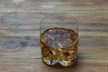 Beautiful view of glass of whiskey with ice on wood background. Beautiful backgrounds. Alcohol concept. 