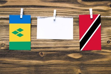 Hanging flags of Saint Vincent And The Grenadines and Trinidad And Tobago attached to rope with...