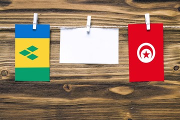 Hanging flags of Saint Vincent And The Grenadines and Tunisia attached to rope with clothes pins...