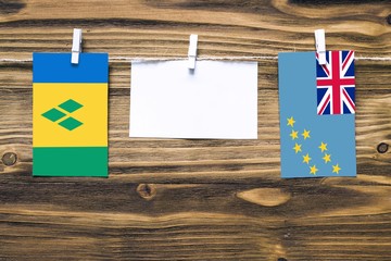 Hanging flags of Saint Vincent And The Grenadines and Tuvalu attached to rope with clothes pins...
