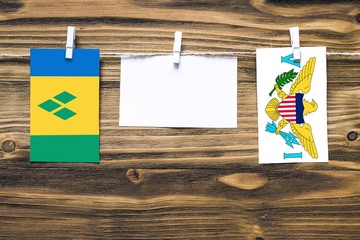 Hanging flags of Saint Vincent And The Grenadines and United States Virgin Islands attached to rope...