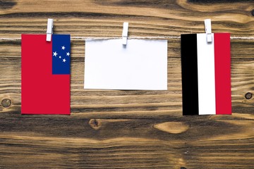 Hanging flags of Samoa and Yemen attached to rope with clothes pins with copy space on white note...