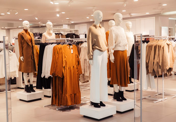 White mannequins in autumn warm and cozy clothes in a store in the Mall.