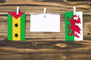 Hanging flags of Sao Tome And Principe and Wales attached to rope with clothes pins with copy space...