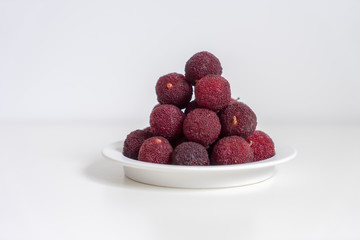 Sweet and sour red fruit bayberry, before a white color background