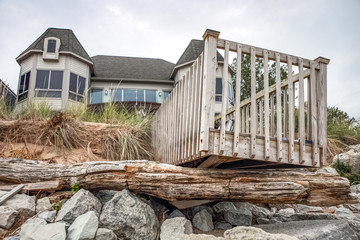 Beach houses on Lake Michigan, lake erosion dangerously close to houses, the wooden deck is destroyed