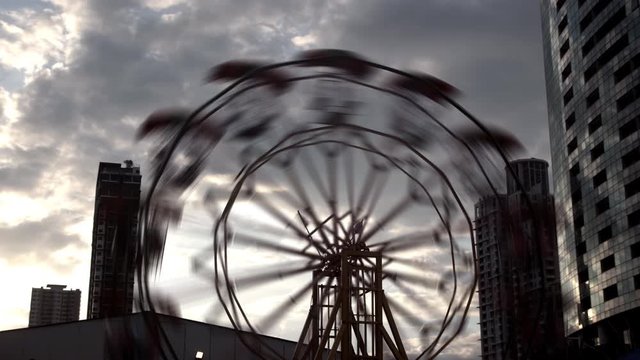 Ferris wheel rotate in evening before sunset in city concept, time lapse, 