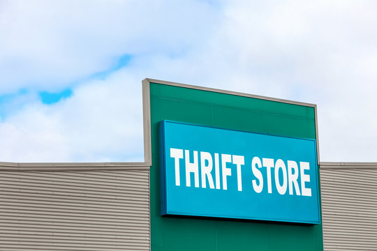 Thrift Store Sign On The Side Of A Building Against A Blue Sky