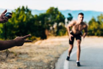 Man hand holding stop watch and measure time for runner