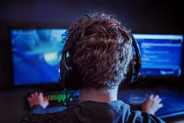 Teenage gamer using a computer to play video games online, extreme shallow focus © soupstock