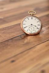 Pocket watch on a wooden surface.