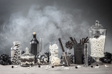 Black and White candy bar with smoke and glass jars and chemistry bottles