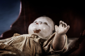 Scary abandoned old baby doll in a cradle