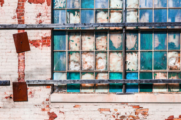 Old industrial windows broken and stuffed with fiberglass insulation